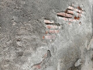 Close-up of a damaged, old concrete wall with peeling plaster and exposed brickwork. The rough, textured surface provides an abstract background useful for construction, decay, or urban themes.  © Din_Wic