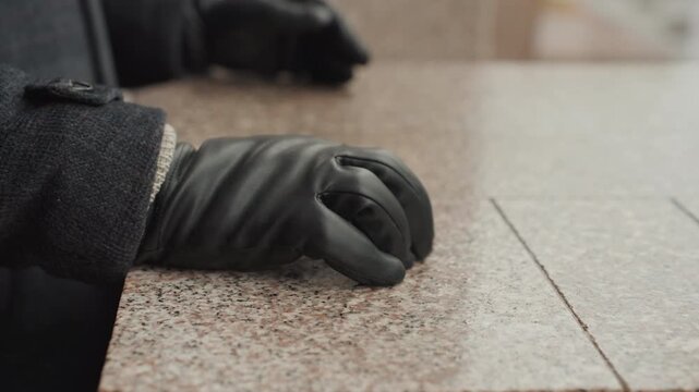 Creator artisan placing hand on granite ledge, closeup of gloved palm settling on polished surface, finishing gesture in urban cold, resolved composition, tactile detail and quiet confidence signaling
