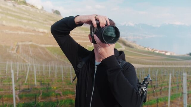 Close up shot of photographer taking pictures in Lavaux during the day with Lake Geneva in Canton of Vaud, Switzerland, static shot