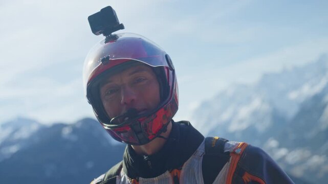 Wingsuit BASE jumper flying over Verbier surrounded by alpine mountains with snow-covered peaks. High-speed flight, dramatic scenery, and cinematic extreme sports action in the Swiss Alps.