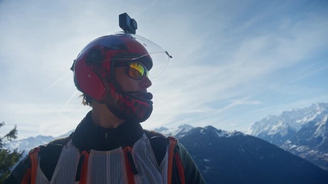 Wingsuit BASE jumper flying over Verbier surrounded by alpine mountains with snow-covered peaks. High-speed flight, dramatic scenery, and cinematic extreme sports action in the Swiss Alps.