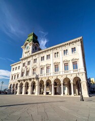 Fototapeta premium Ornate white building with clock tower under bright, cloudless, blue sky