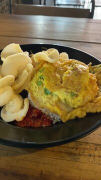 Indonesian fried egg omelette with rice and crispy crackers
