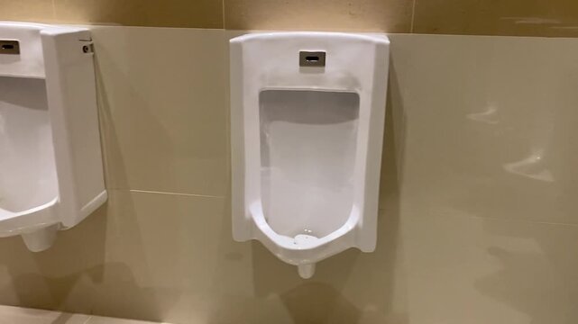 Interior layout of a modern men's restroom with urinals and stalls