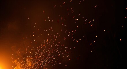 Close up of glowing sparks and embers flying through dark night sky creating a fiery and dynamic scene perfect for industrial or safety themed projects
