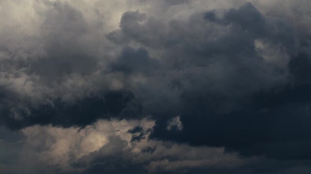 Timelapse of dark storm clouds moving rapidly across the sky as weather deteriorates before a thunderstorm, dramatic atmospheric buildup with dense thundercloud formations signaling approaching severe