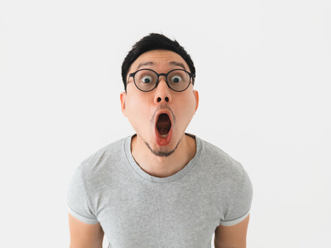 Asian man with wide eyes displays intense shock and surprise