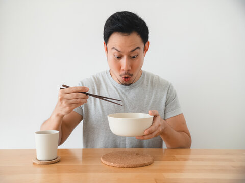 Asian man amateur reviewer sampling soup, concentrated tasting