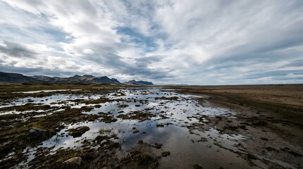 Fototapeta premium Wet land surface reflecting sky creating surreal mirror illusion landscape for abstract nature concept