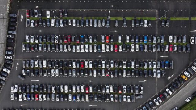 Aerial view of a car parking lot filled with many cars of various colors, neatly arranged in rows, Porto, Portugal.