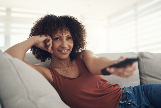 Relax, streaming and watching tv with woman on sofa in home living room for subscription service. Channel surfing, remote and television with happy person in apartment for film, movie or series