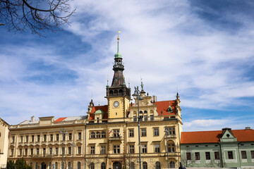Obraz premium Historic town hall with clock tower under a bright blue sky with wispy clouds