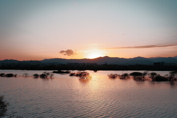 Fototapeta premium Dramatic red sunset sky reflected on a dark river