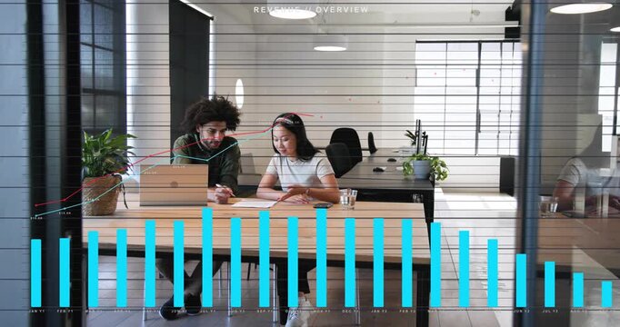 Man placing laptop while peer pointing, blue bars and red line rising over papers, checking revenue