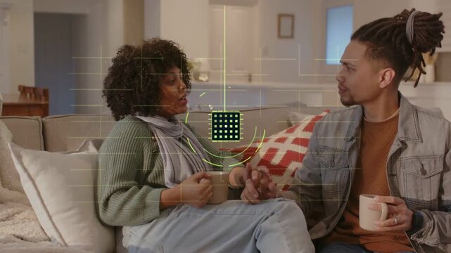 Pair sitting on sofa holding mugs clasping hands starting HUD matrix rising between them for tech