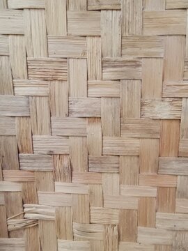 Texture of a bamboo mat. Close-up of woven bamboo mat with crisscross pattern, highlighting natural tones and traditional craftsmanship.