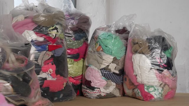 Fast fashion waste piles in bags of used clothes and shoes environmental crisis concept