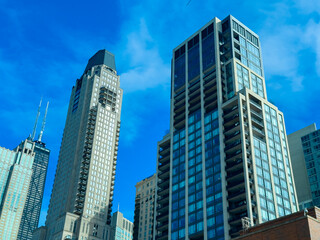 Obraz premium City skyline shows tall buildings against blue sky in urban area during daytime with clear weather and visible clouds above