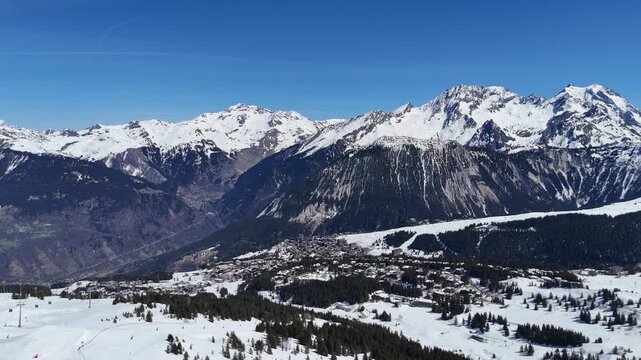 Aerial panaromic view of Courchevel 1850, ski resort 1650 and Bozel between snowy mountains.