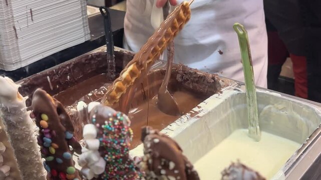 Kurtos chimney cake preparation Hungarian Czech sweet dough rolled over spit traditional baked dessert street food