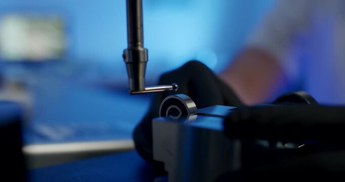 Precision coordinate measuring machine probe testing a steel ball bearing in a technical laboratory