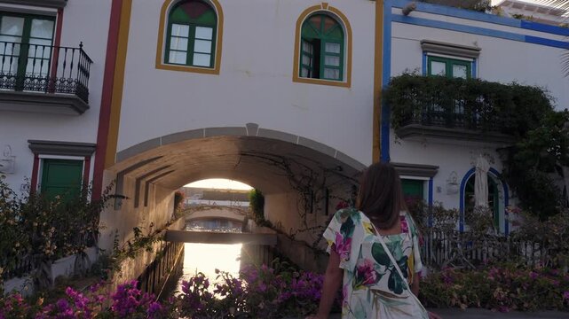 Woman enjoying the sunset over a canal in the charming fishing village of Puerto de Mogan, a popular tourist destination