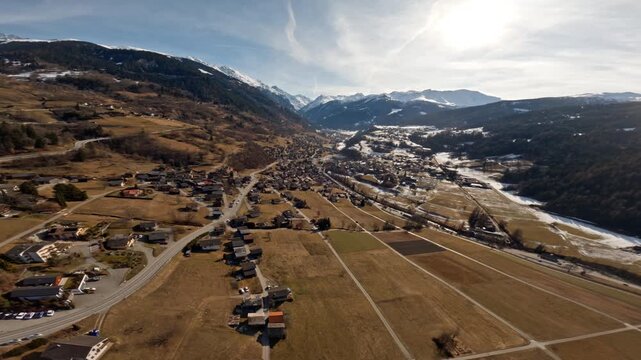Wingsuit BASE jumper flying over Verbier surrounded by alpine mountains with snow-covered peaks. High-speed flight, dramatic scenery, and cinematic extreme sports action in the Swiss Alps.