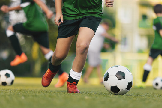 Youth Soccer Game Action; Kids Running and Dribbling Ball During Football Match on Field