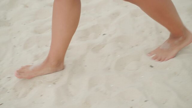 Gentle steps along peaceful sandy coast. Relaxing barefoot walk on bright sunlit shoreline with gentle waves. Calm scene of barefoot footsteps across shimmering white sands on sunny seaside day