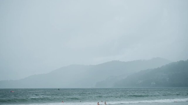 Turbulent sea under stormy sky. Vast turbulent shoreline overtaken by storm and thick fog. Agitated ocean scene with violent waves crashing against obscured coastlines shrouded in mist