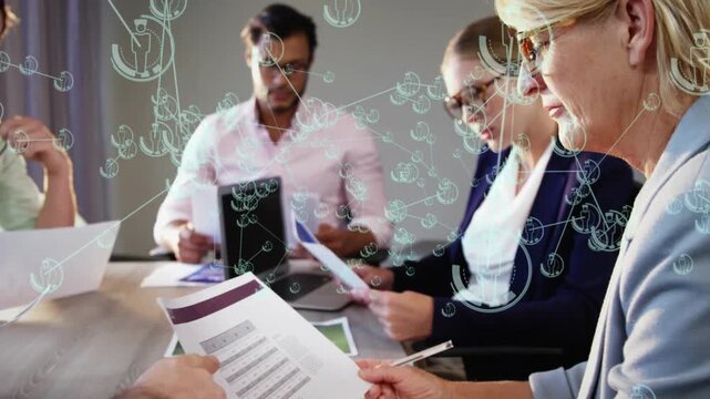 Team studying business docs after off-frame pointing, network overlay marking table docs for review