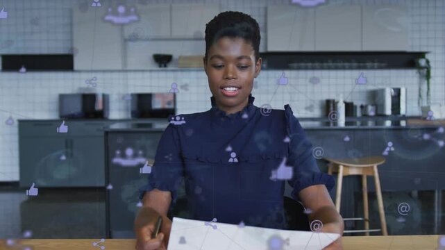 Vertical video: Host glancing paper reading gesturing social icons floating in front for marketing
