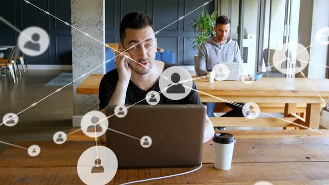 Man checking phone then calling, animated network icons expanding across laptop for business