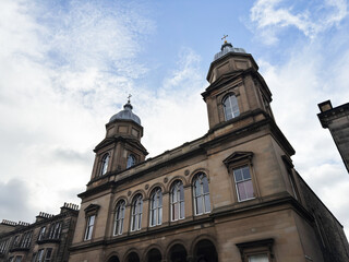Fototapeta premium Historic sandstone Palmerston Place Church building with twin towers and arched windows in Edinburgh, Scotland, UK showcasing classical architecture and civic heritage