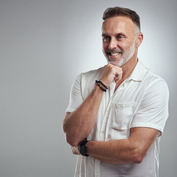 Think, journalist and man with smile in studio, planning feature article angle and news reporting career. Brainstorming, space and mature writer with idea for story, reflection and white background