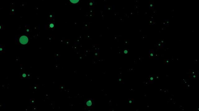 Green glowing particles floating in darkness with black background  