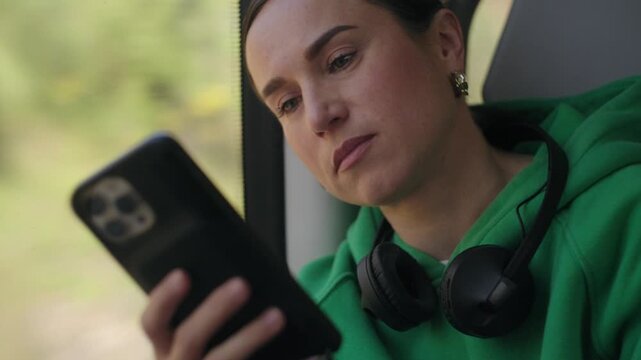 Tired Woman Yawns While Using Smartphone on a Train