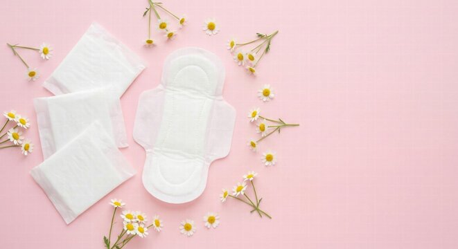 Sanitary pads with chamomile flowers on a pink background, symbolizing feminine hygiene, menstruation care and comfort. Clean composition with copy space for advertising