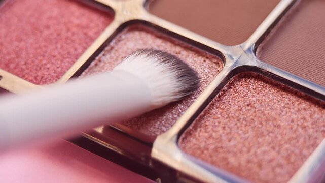 Detailed close-up makeup brush applying nude eyeshadow pigment, smooth movement and soft color palette. Suitable for professional makeup tutorials, branding and cosmetic marketing