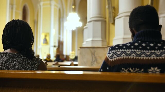 Faithful individuals praying inside a Catholic Church during a religious service