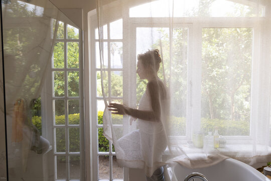 portrait of pensive young woman in bathroom