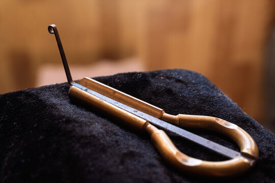Brass jaw harp musical instrument resting on a dark velvet cloth
