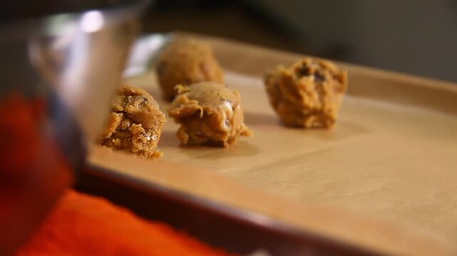 Video of chocolate chip cookies being prepared for baking.