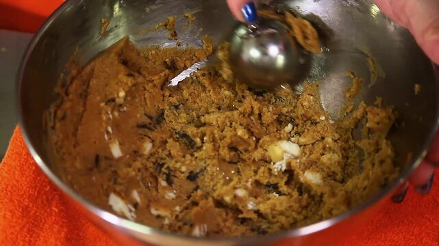 Video of chocolate chip cookies being prepared for baking.