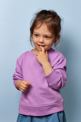 cute little child girl with finger on mouth, looking away, indicating thought and childhood...