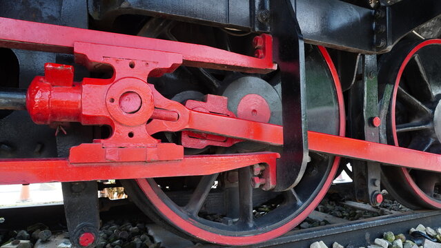 Classic steam train bogie featuring large diameter wheels and mechanical pistons