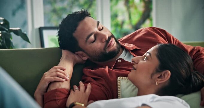 Couple, relax and smile on sofa with kiss, romantic connection and bonding together on weekend break. Happy, people and affection in home with support, trust and love commitment for healthy marriage.