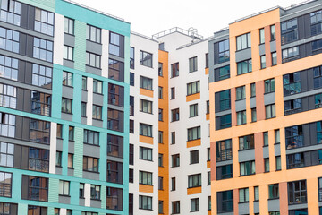 Fototapeta premium Modern apartment buildings with colorful facades. Clean lines and geometric windows dominate the scene. Bright hues contrast with neutral tones in the architecture