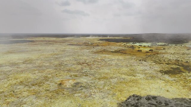 Aerial view of the Dallol hydrothermal field, showcasing colorful mineral deposits in northern Ethiopia&rsquo;s Afar Depression. Drone footage flying thru the steam.