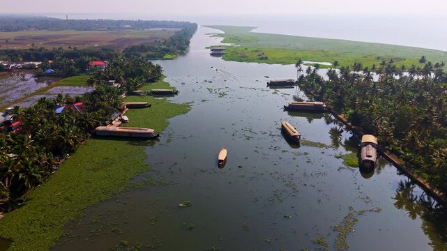 Drone approaching a small Kettuvallam houseboat in the canals of Kochi, India